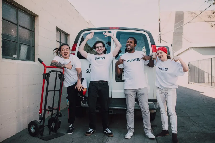 Smiling volunteers in front of a van
