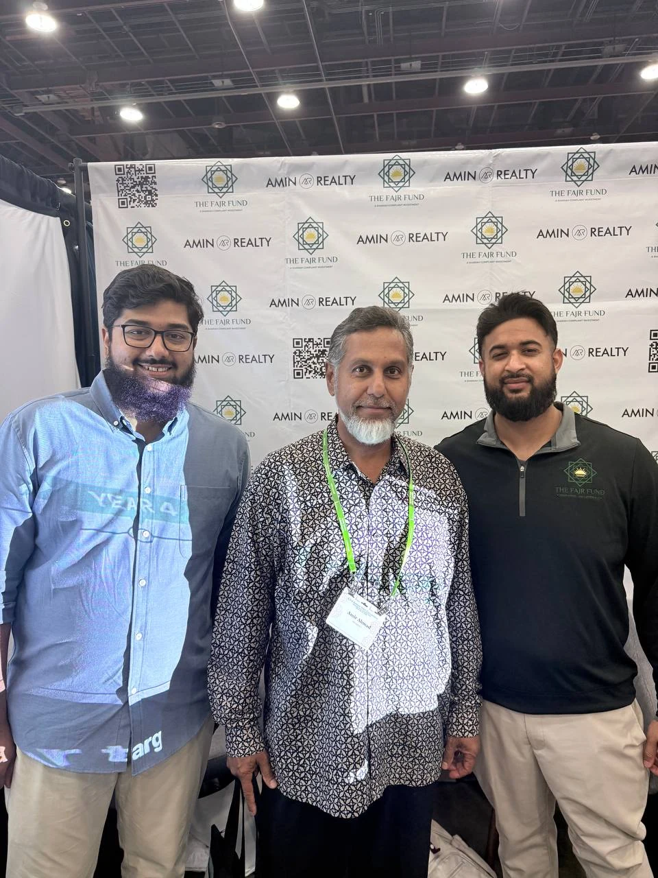 Three people together at the Fajr and Amin Realty booth at ISNA.