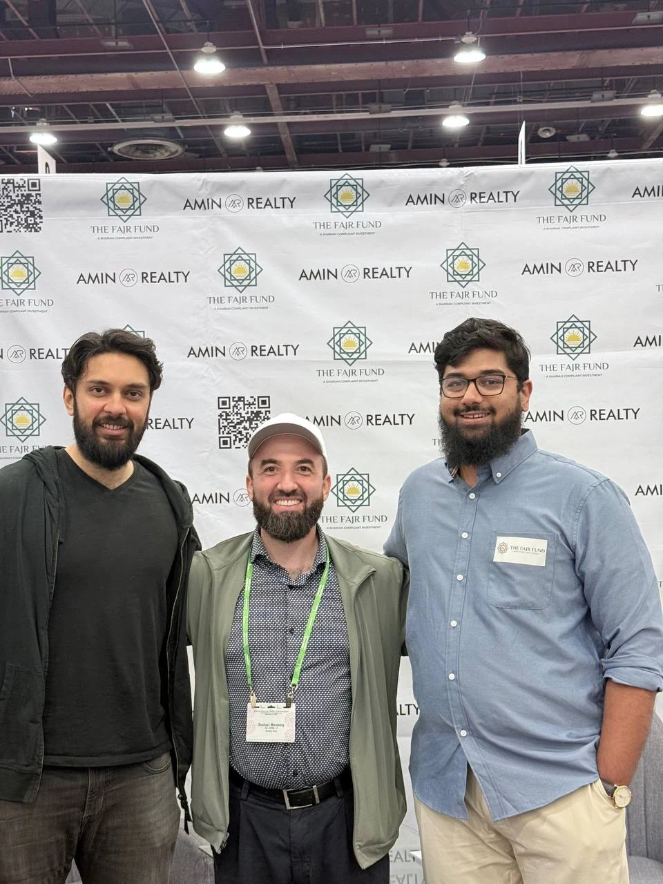 Three attendees posing together at the Fajr booth at ISNA.